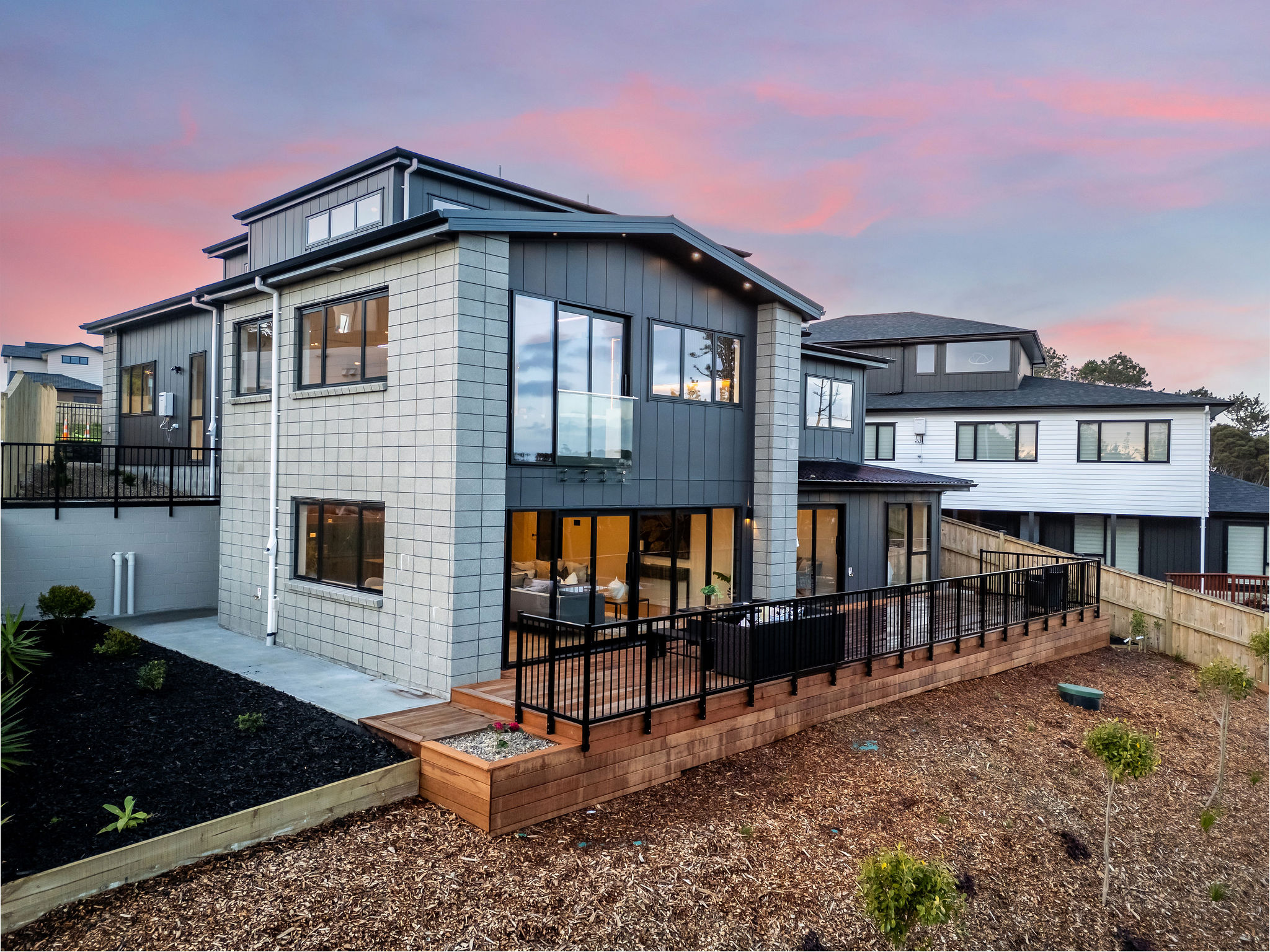 Rear corner and wraparound deck at dusk