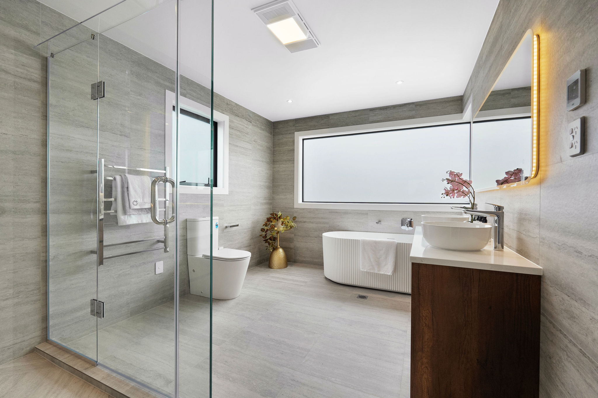 Bathroom with freestanding tub and warm timber vanity