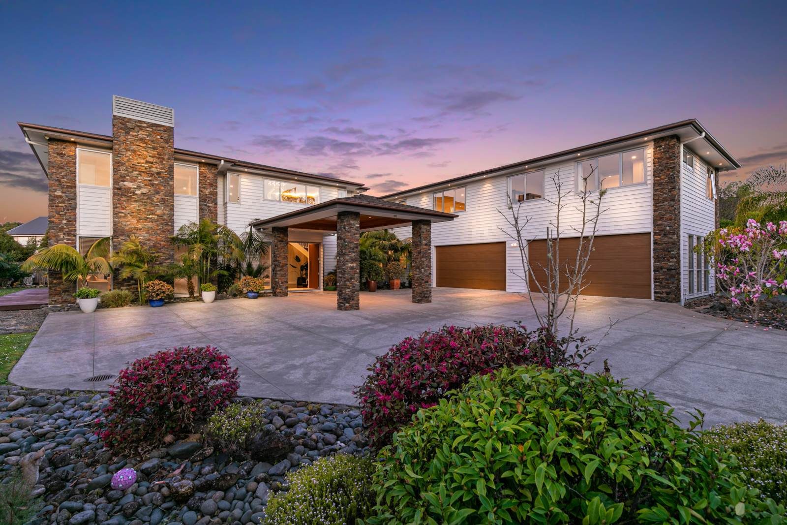 Completed Greenhithe family home at 2A Oscar Road, viewed from the landscaped arrival at dusk