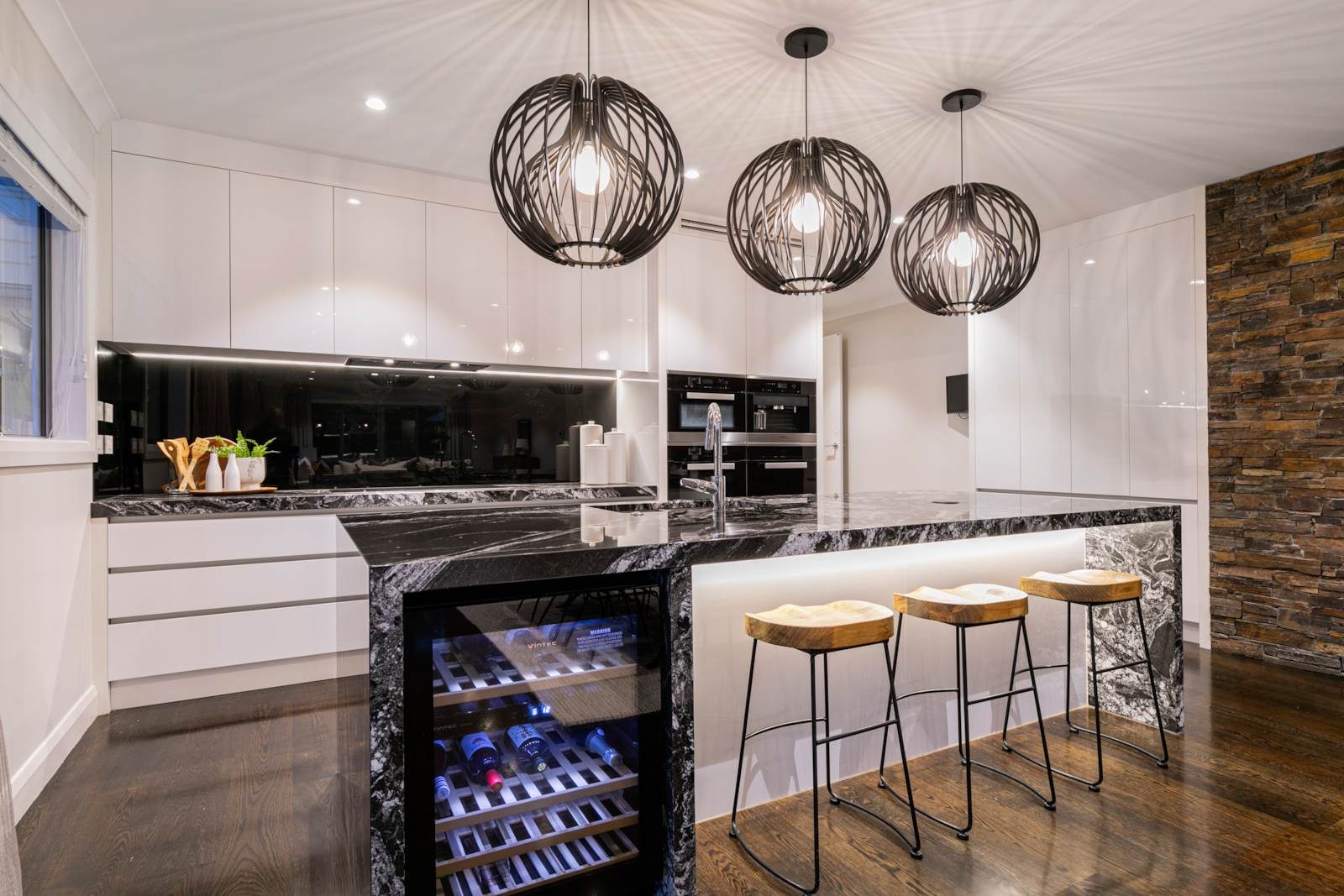 Kitchen with stone island and sculptural pendant lighting