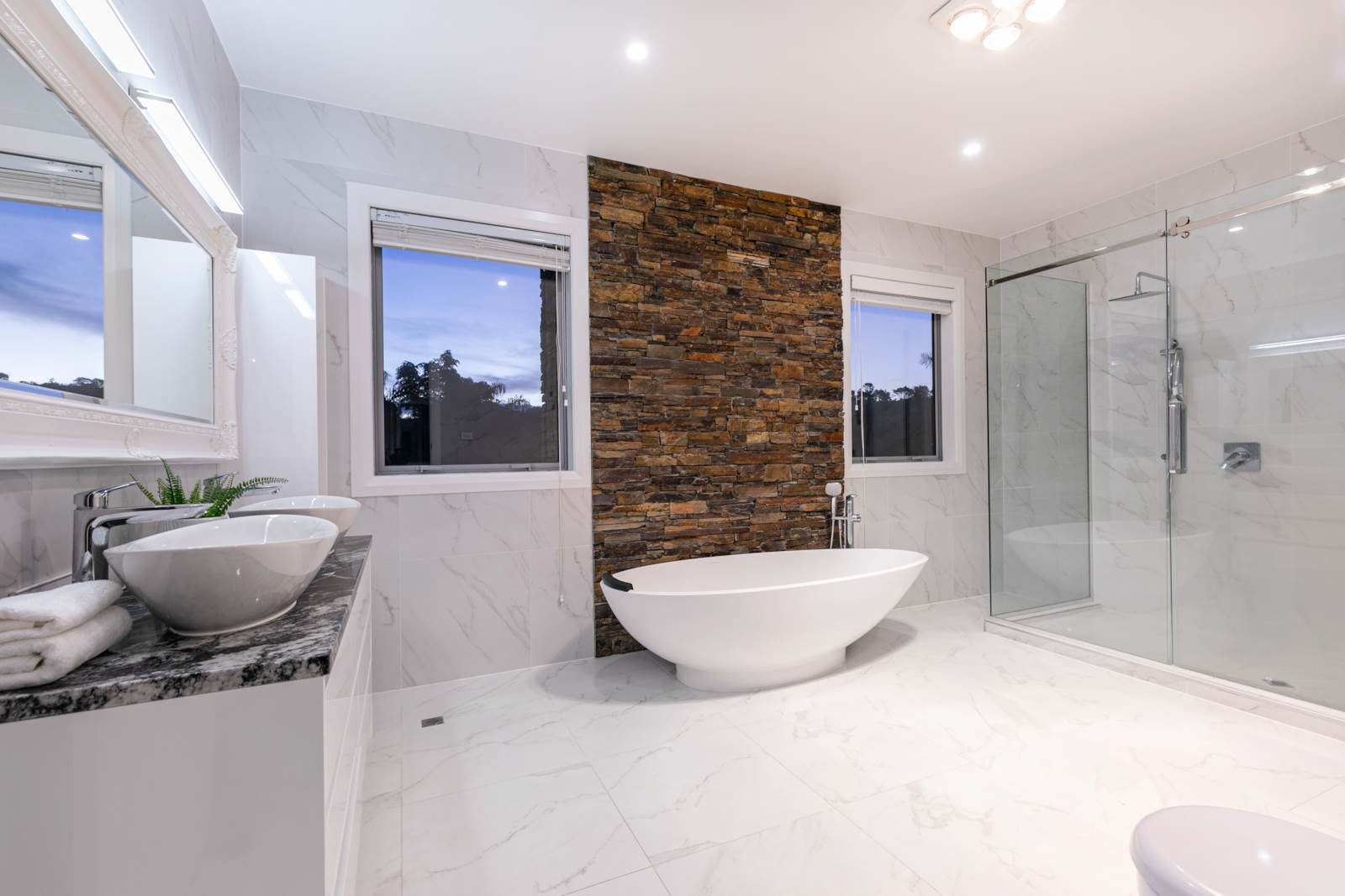 Bathroom with freestanding bath and stone feature wall