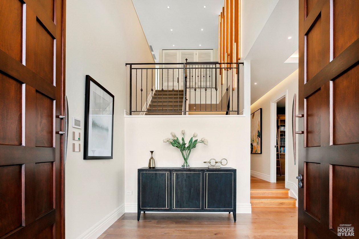 Double-height entry hall with timber joinery and stair