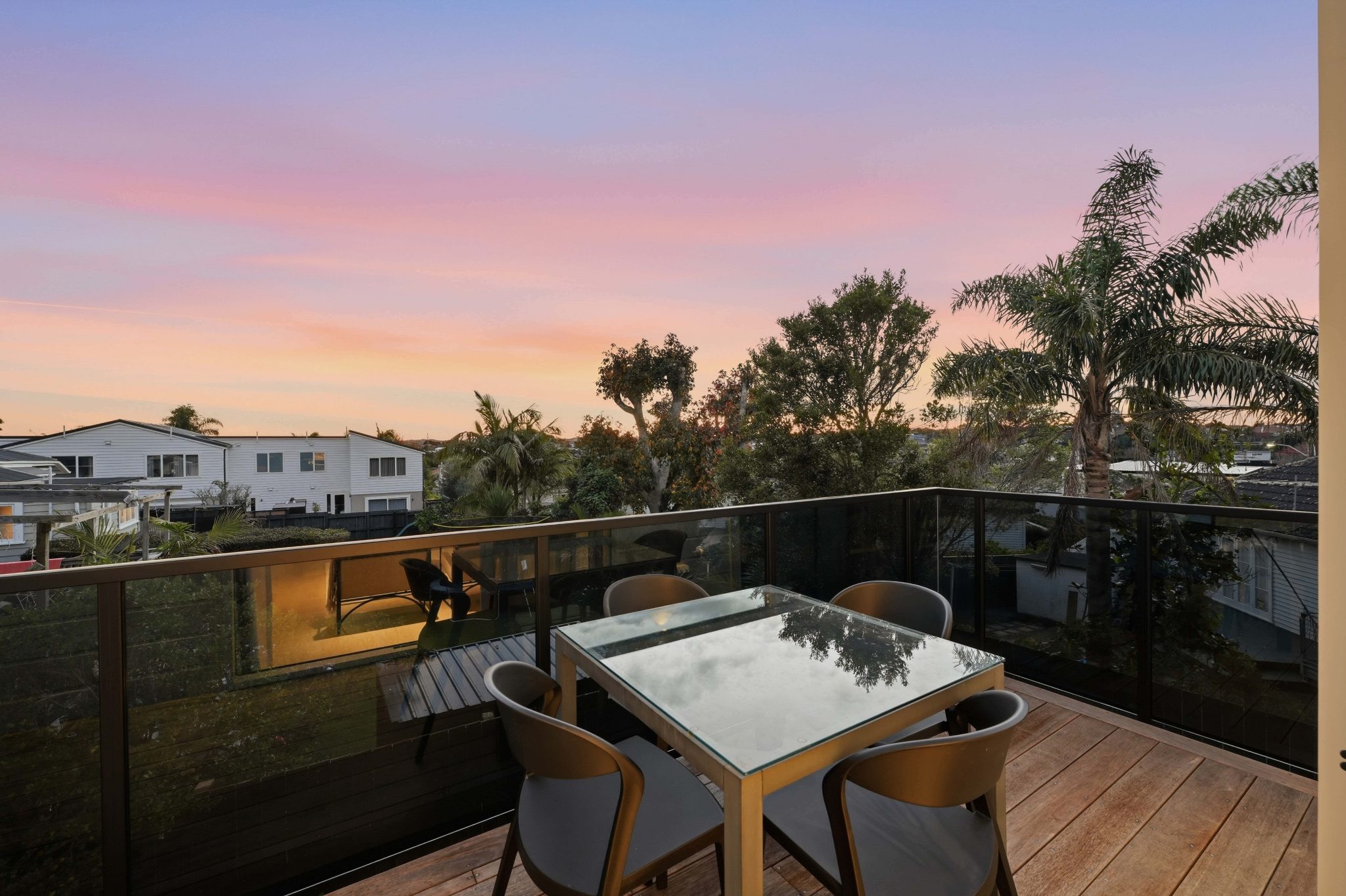 Upper-level balcony with views across the neighbourhood at sunset