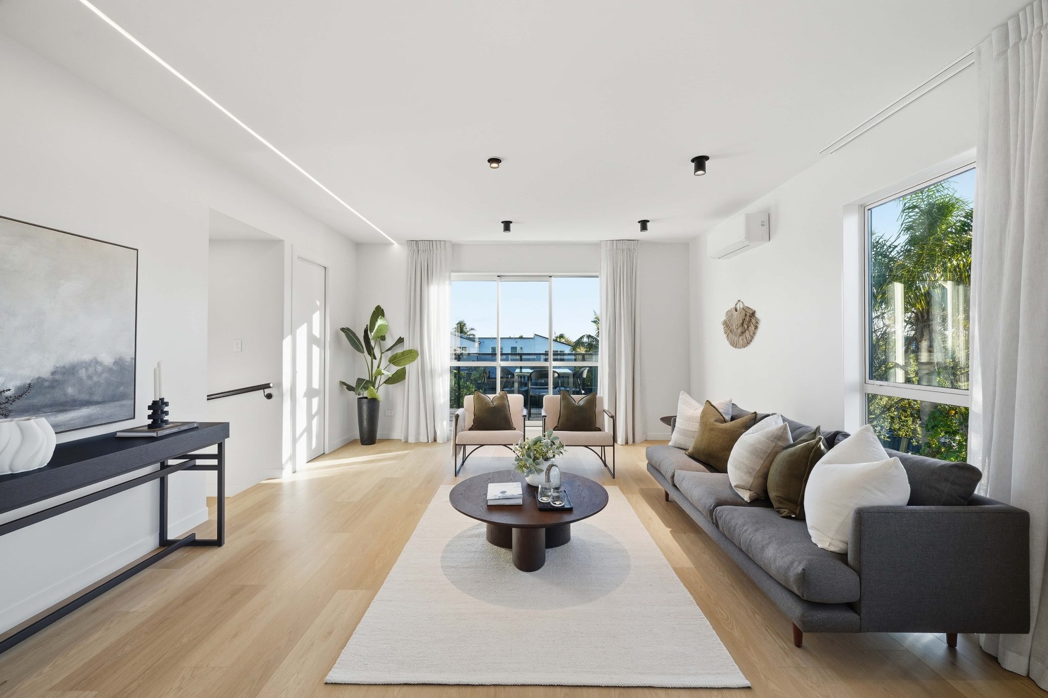 Light-filled living room with a broad window and pale timber floor