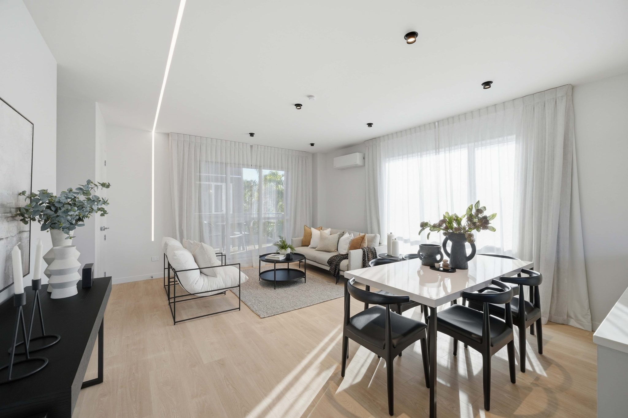 Living and dining space with full-height glazing and soft natural light