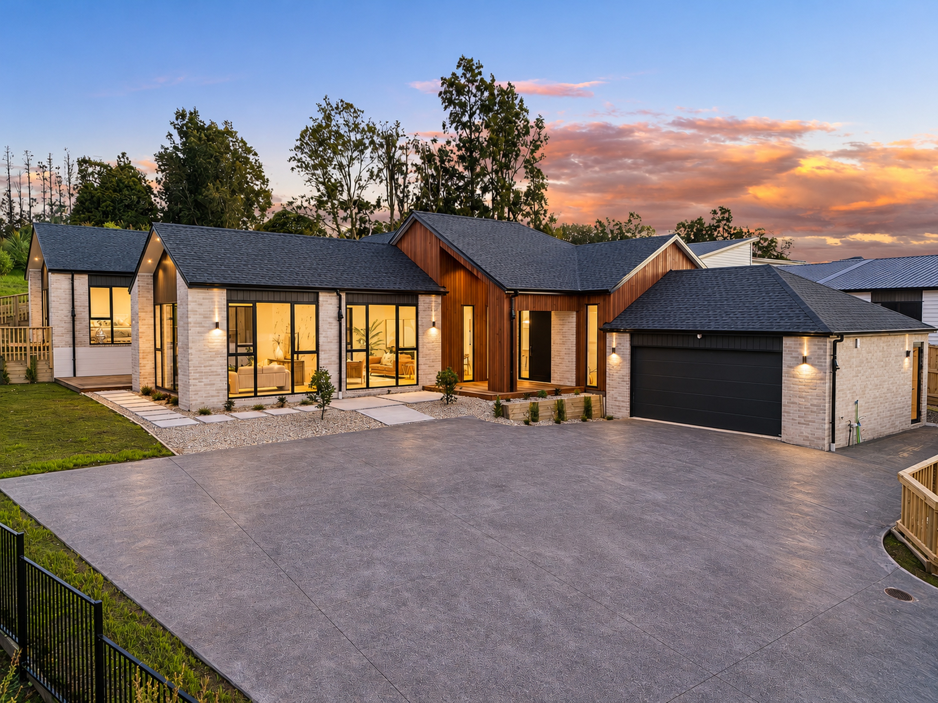 Pitched roofs, brick walls and timber entry of the main Katote Avenue home at dusk