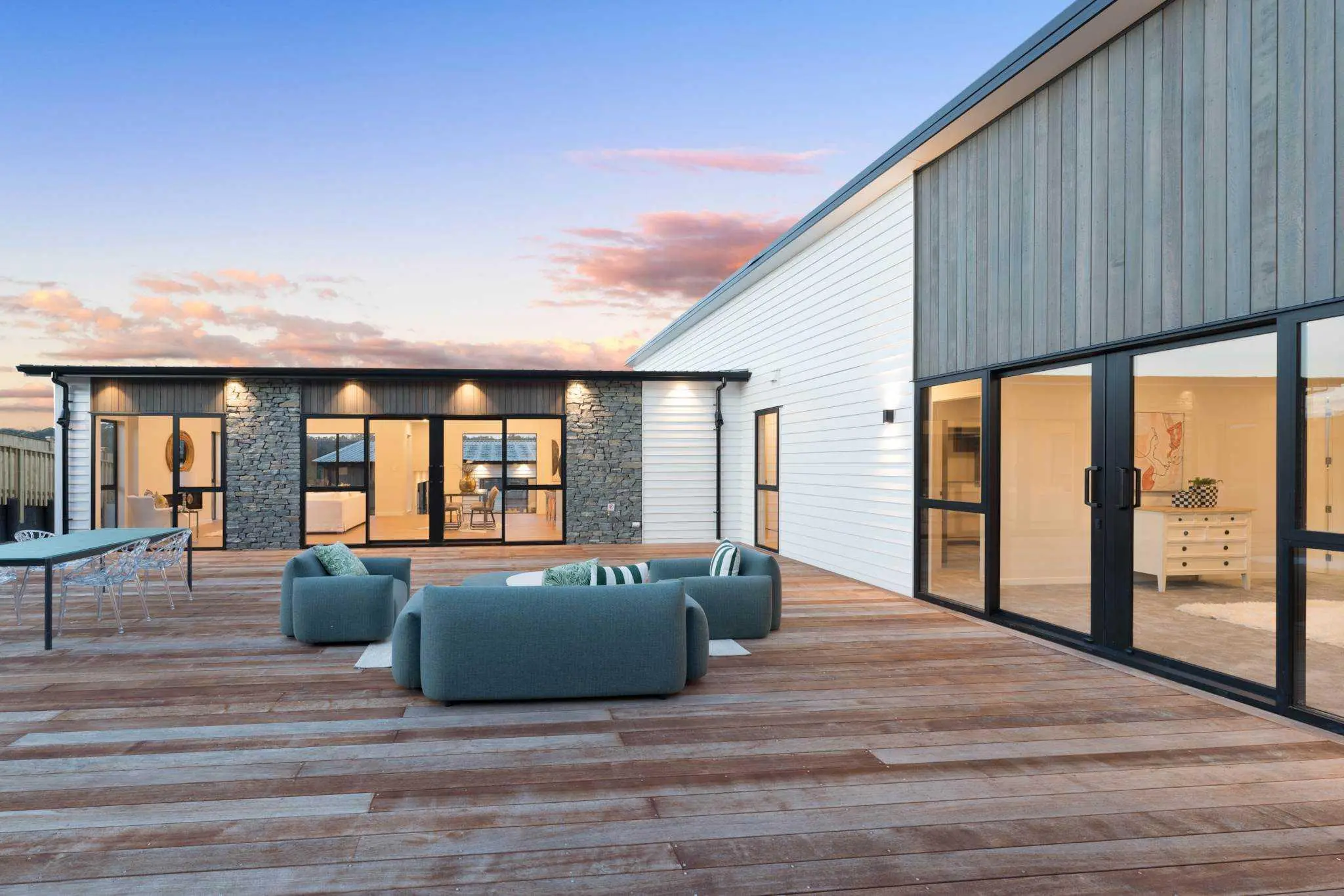 Large outdoor deck connecting the home to the courtyard and garden