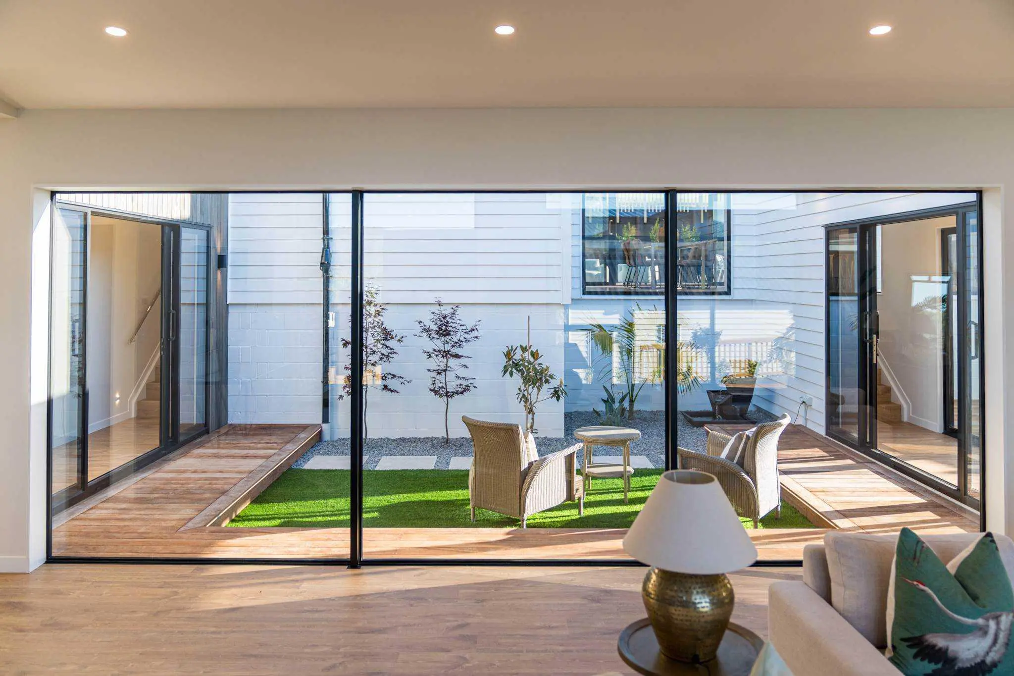 View from the living room through full-height glazing to the courtyard