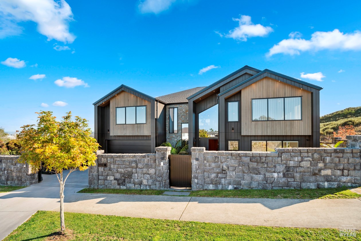 Street facade of the Kewa Road home with stone walls and dark timber cladding