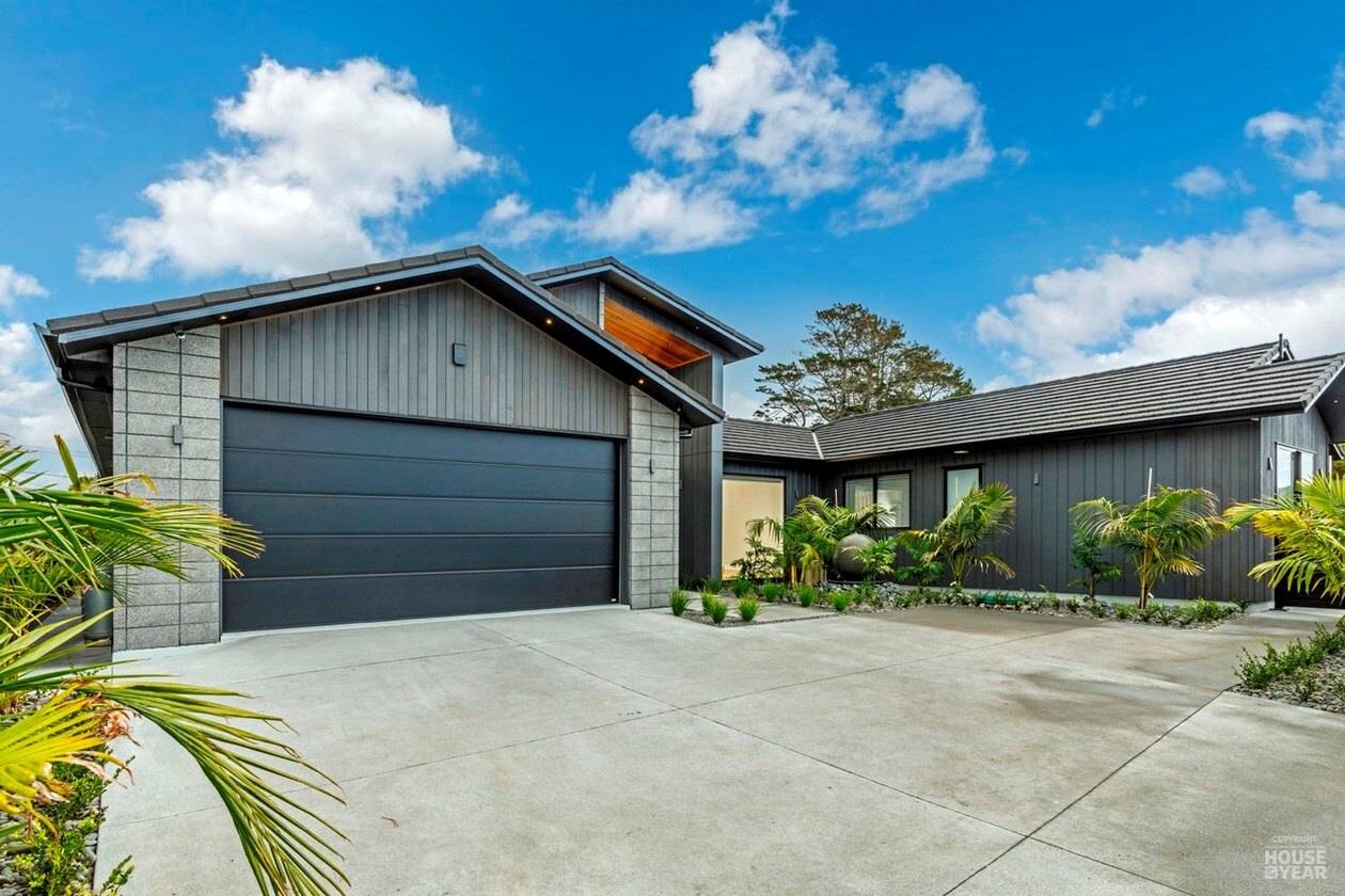 Front elevation of 44 Kewa Road with stone, dark cladding and landscaping