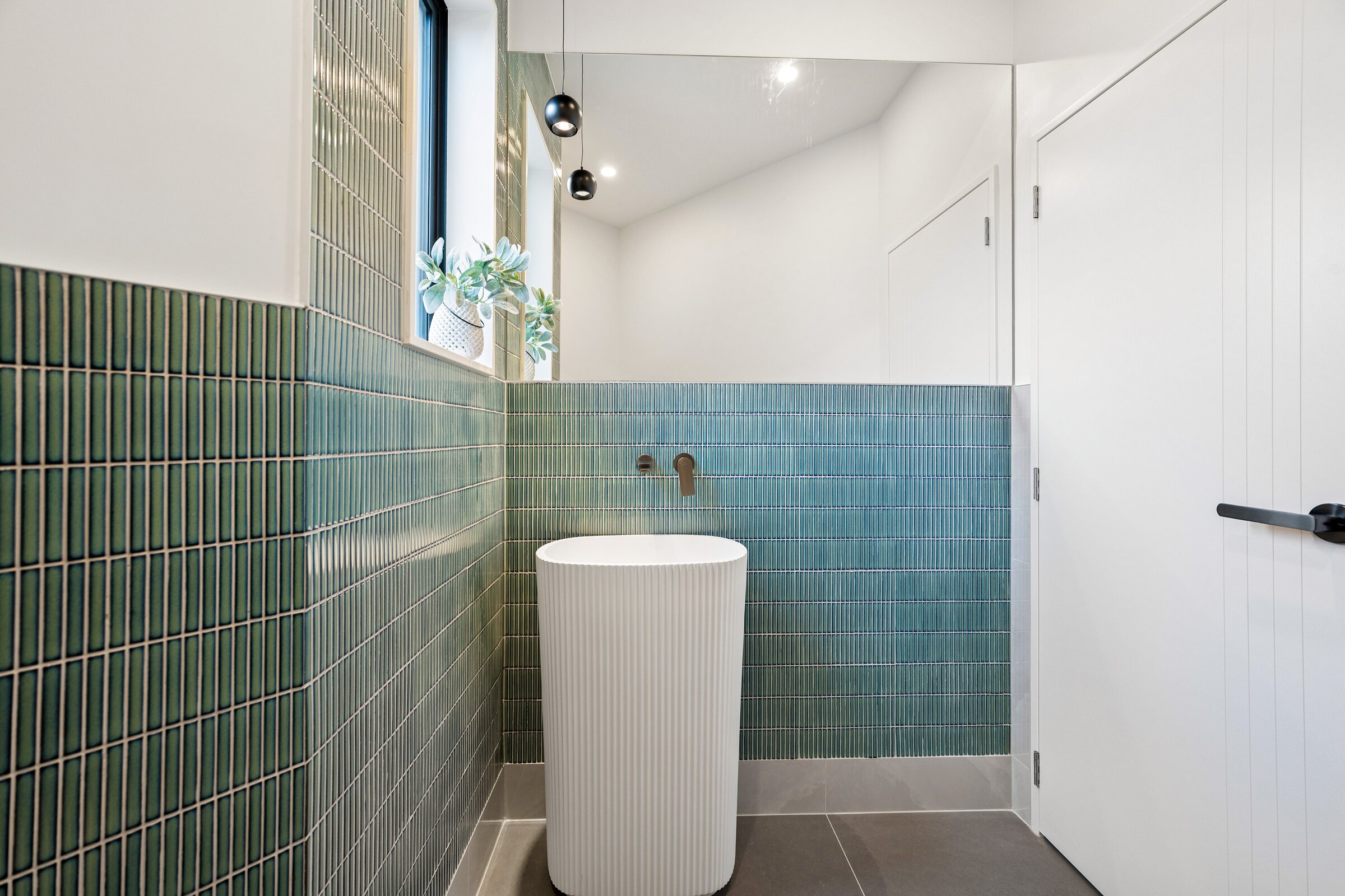 Green-tiled powder room at 73 Kewa Road