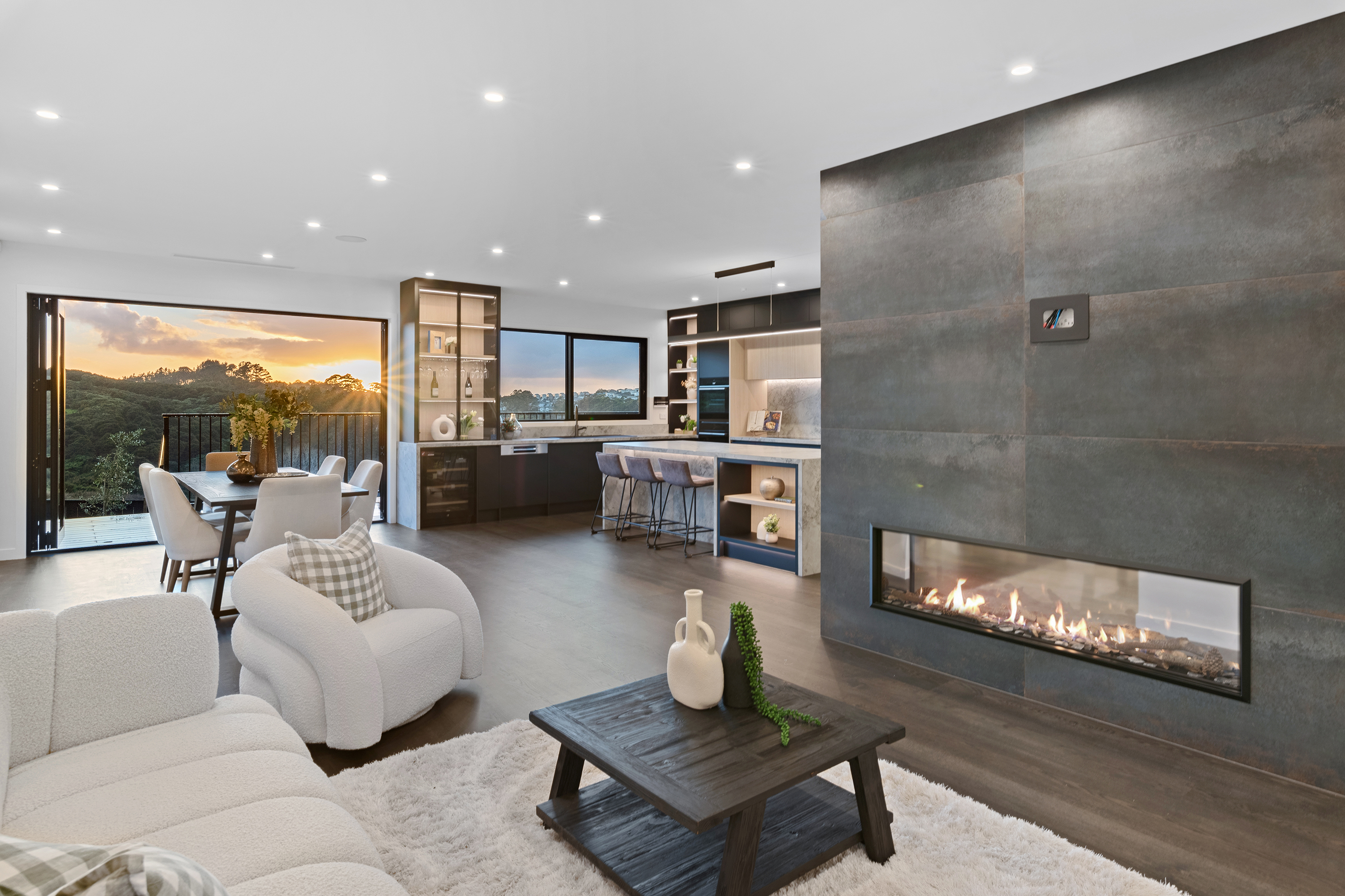 Living room at 22 Kikorangi Drive with fireplace and sunset views