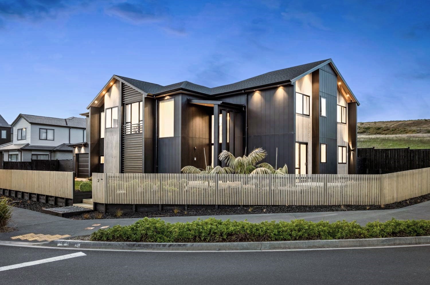 Gabled five-bedroom home at 2 Kumukumu Road with dark cladding at dusk