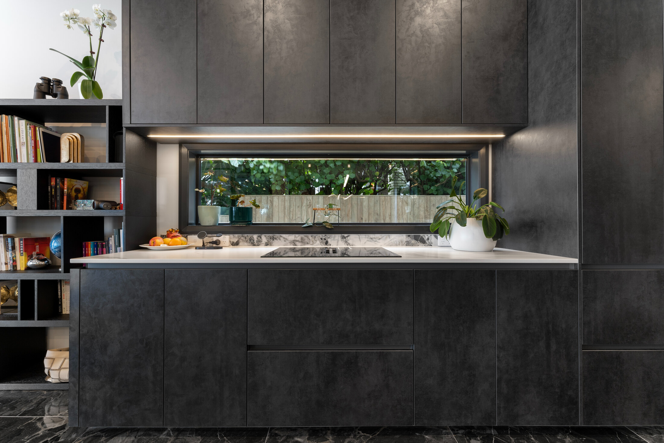 Dark joinery and picture window within the kitchen