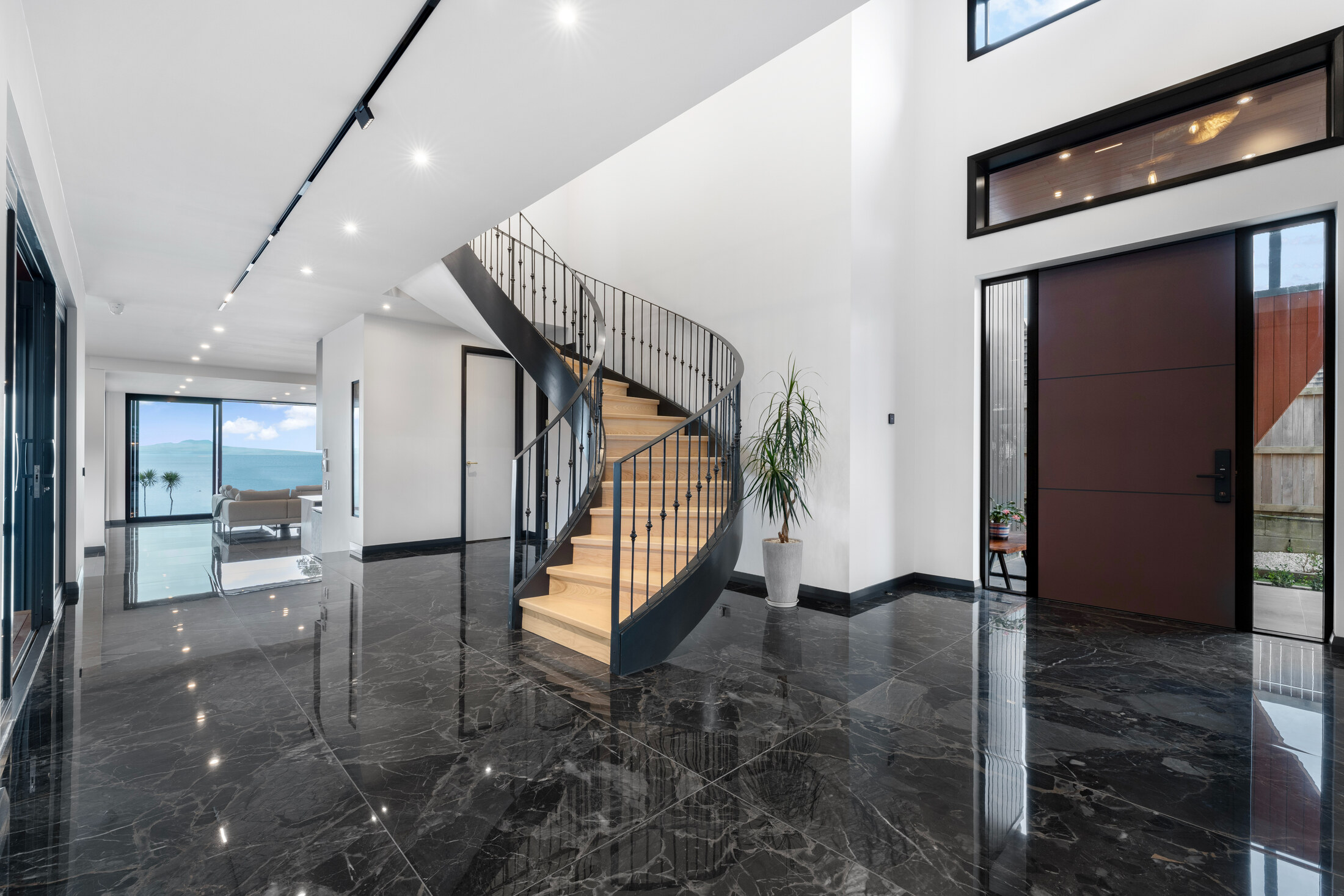 Double-height entry with sculptural curved stair