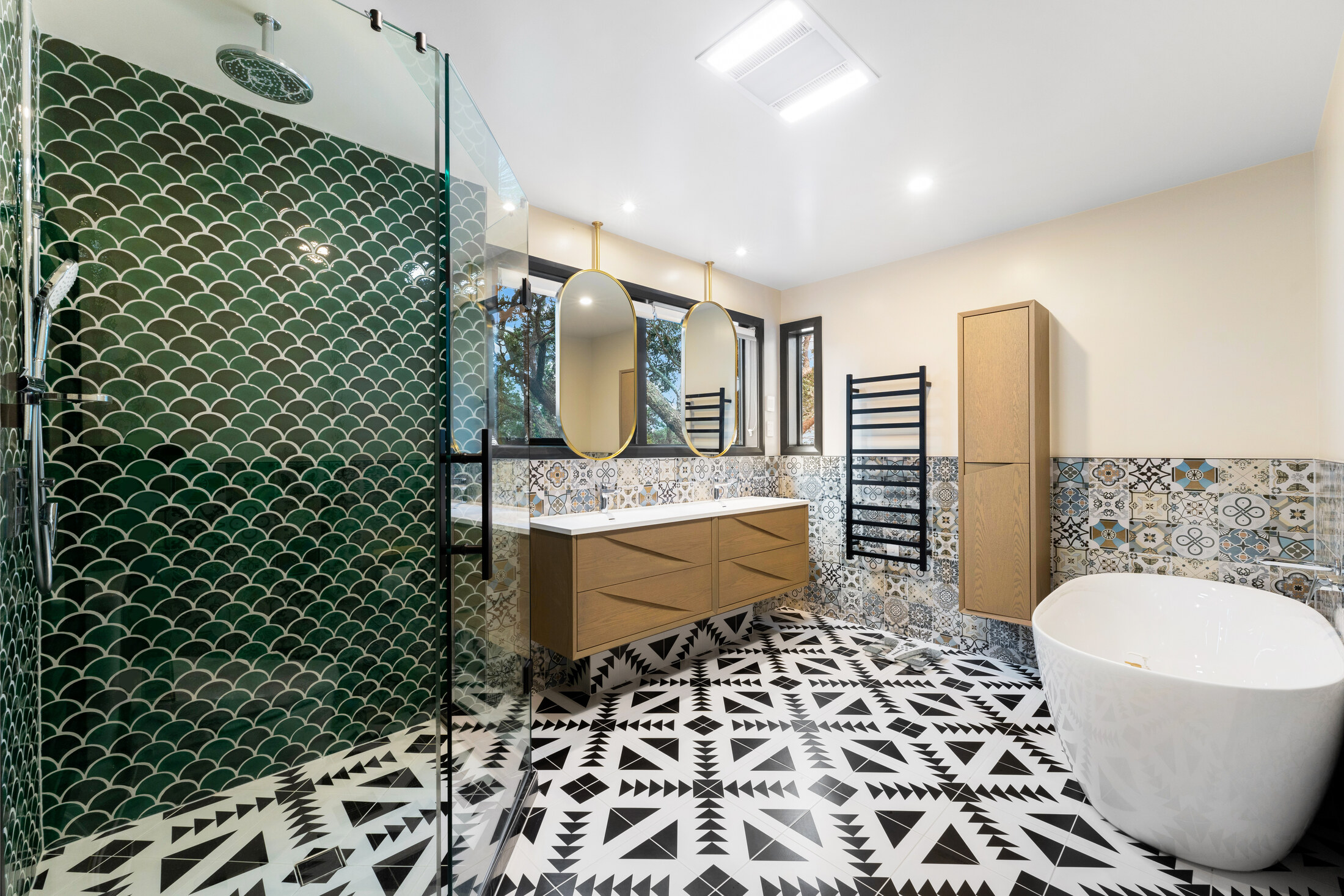 Principal bathroom with patterned floor and green tiled shower